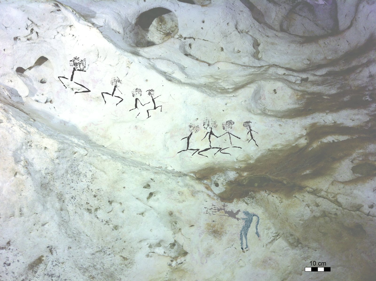 Ancient narrative rock-art figures painted on a cave wall in East Kalimantan